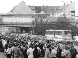 Menschenmassen warten auf die Weiterreise nach West-Berlin, einen Tag nach dem Mauerfall