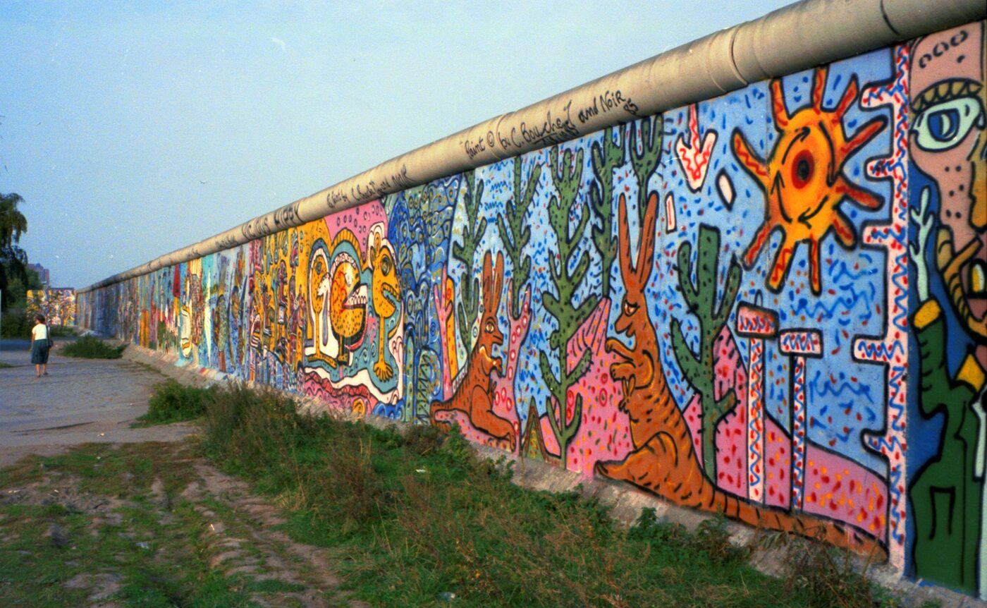 A section of the Berlin Wall painted with bright cartoon figures by Thierry Noir and Christophe Bouchet in October 1985