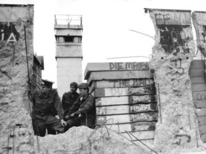 Soldati di frontiera e una torre di guardia accanto a un varco nel Muro di Berlino, aprile 1990