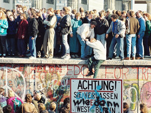 Menschen auf der Berliner Mauer nahe dem Brandenburger Tor, 9. November 1989