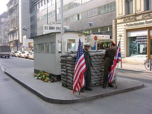 Checkpoint Charlie heute, mit Laiendarstellern als Soldaten, die für Fotos posieren und Pässe abstempeln
