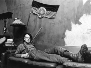 Un giovane punk della Germania Est disteso sotto una bandiera della RDT in un appartamento occupato di Berlino Est