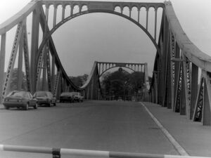 Glienicker Brücke von Westen gesehen im April 1989, mit dem DDR-Schriftzug 'Brücke der Einheit' am Bogen