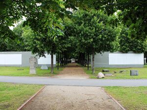 Baumbestandene Allee mit Mauersegmenten auf dem Invalidenfriedhof
