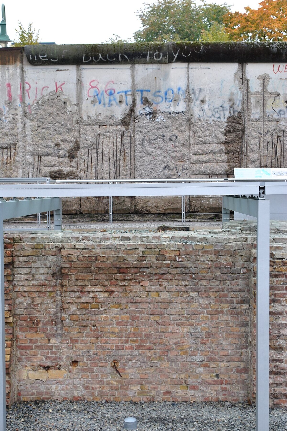 Nahaufnahme der Berliner Mauer an der Niederkirchnerstraße mit Schäden durch Souvenirjäger