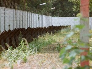 Grenzzaun um die Eisenbahnstrecke nach Steinstücken, mit Panzersperren